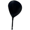 A black golf driver is positioned upright showcasing its angled clubhead with a smooth surface reflecting light the context is a neutral background emphasizing the driver’s design and details.