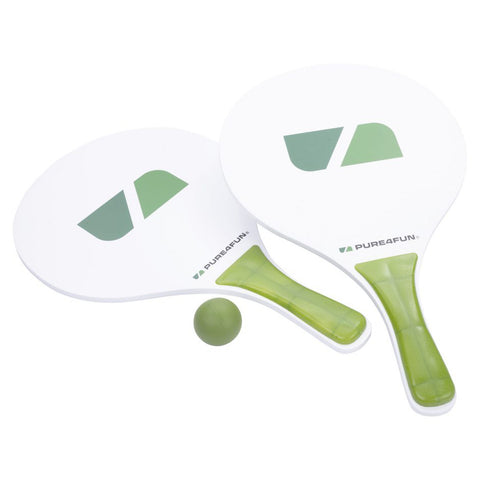 Two white paddle rackets with green accents rest beside a small green ball in a neutral environment, suggesting a setup for a recreational game like paddleball or beach activities.