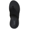 A black flip-flop is centered in the image with a textured sole and a soft fabric strap at the top conveying a casual and comfortable design suitable for warm weather.