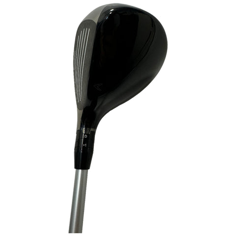 A golf club head is displayed with a sleek black finish and marked grooves on the face indicating a focus on precision The shaft is silver and attaches just below the head