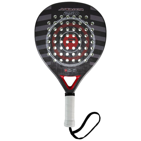 A paddle with a black and red design featuring a circular pattern and multiple holes is positioned upright. It is designed for racquet sports and has a textured handle for grip.