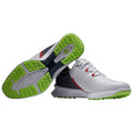 Footwear designed for golf features a predominantly white upper with red and black accents the sole has a textured green rubber for traction positioned on a plain background