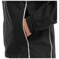 A black waterproof jacket is shown with a hand casually placed in its side pocket highlighting the garment's design features and the relaxed fit suitable for outdoor activities.