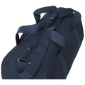 A navy duffel bag with sturdy handles sits partially zipped showcasing its spacious interior intended for carrying clothing or gear in various travel or sporting contexts.