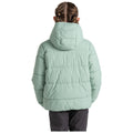 A child wearing a mint green puffer jacket with a hood stands with their back facing the viewer in a neutral, well-lit environment showcasing the garment's puffy texture and casual style.