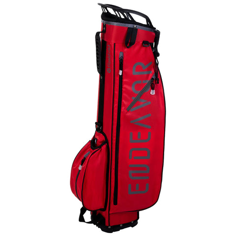 A red golf bag stands upright featuring several compartments and zippers holding golf clubs and accessories positioned against a plain white background