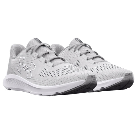 Gray athletic shoes with a textured surface are positioned side by side showcasing their design and branding in a neutral background with no distractions around them.