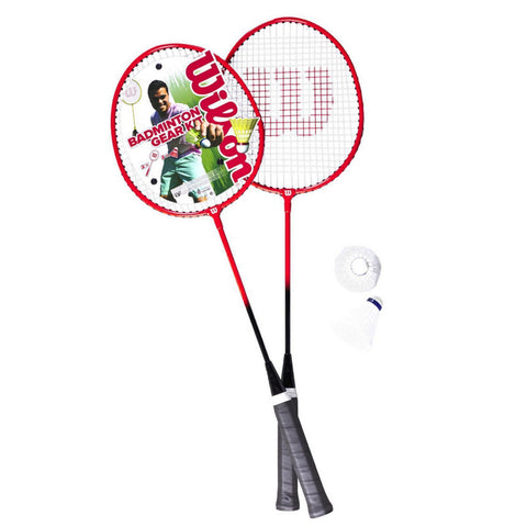 Two badminton rackets are crossed at their handles with red frames and black grips showcasing a branded logo while a shuttlecock rests nearby against a white background.