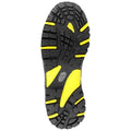 A textured black rubber shoe sole with yellow accents rests flat showing deep tread patterns designed for traction and stability suitable for outdoor activities or rugged terrain.