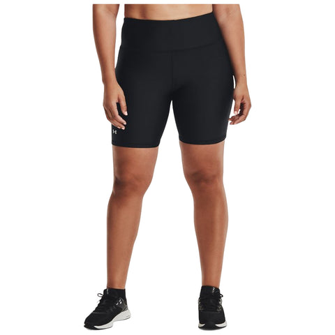 A person stands wearing black athletic shorts and shoes with a focused expression. They are in a neutral background, showcasing activewear suitable for exercise or sports activities.