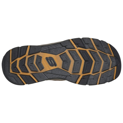 A black and beige sneaker sole features an intricate tread pattern designed for traction grips showcasing raised sections and grooves in the rubber material suitable for outdoor activities.