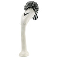 A white sock with a black and white pom-pom design stands upright, resembling a cartoonish character with a long leg and a Nike logo embroidered on its surface.