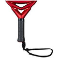 A red paddle includes a textured black grip with a wrist strap attached which supports gameplay in racquet sports in an environment designed for recreational activity.