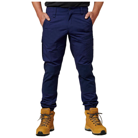 Navy cargo pants are worn by a person standing, with hands in pockets. The individual is paired with bright yellow boots, suggesting a casual outdoor or work environment.