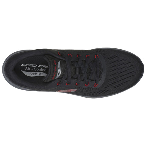 A black athletic shoe with red accents is displayed from above featuring a breathable mesh upper with laces and a cushioned insole labeled Air Cooled ArchFit suggesting comfort and support for active use.