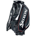 A golf bag is standing upright featuring black and white design with prominent Srixon branding and a Cleveland Golf logo alongside a compartment for storing golf equipment and accessories.