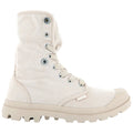 A light-colored canvas boot stands upright showcasing a high top with eyelets and laces while featuring a rugged sole designed for traction in varied terrains.