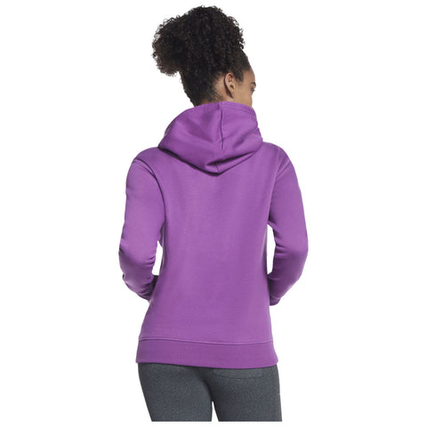 A person wearing a purple hooded sweatshirt stands with their back to the viewer in an undefined environment, showcasing the garment's vibrant color and casual design.