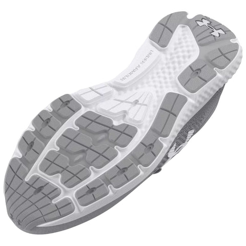 A gray and white athletic shoe sole is positioned upward showing its tread pattern designed for grip and traction on various surfaces while highlighting its durability and style in a neutral background.