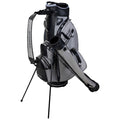 A golf bag is displayed upright with a stand extended the bag is equipped with various storage pockets and a handled strap set against a plain background.