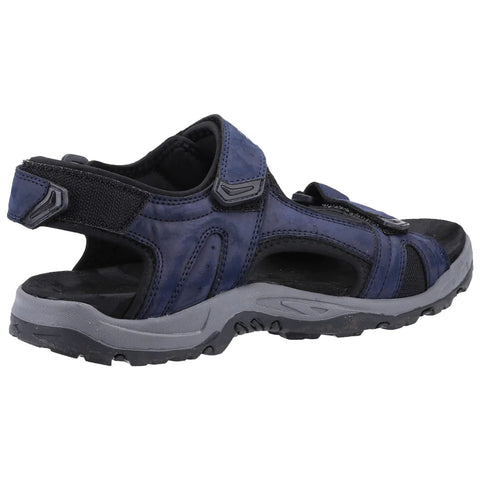 Footwear is a dark blue sandal featuring a rugged sole and adjustable straps designed for comfort and stability in outdoor settings, showcasing a sporty design suitable for casual wear.