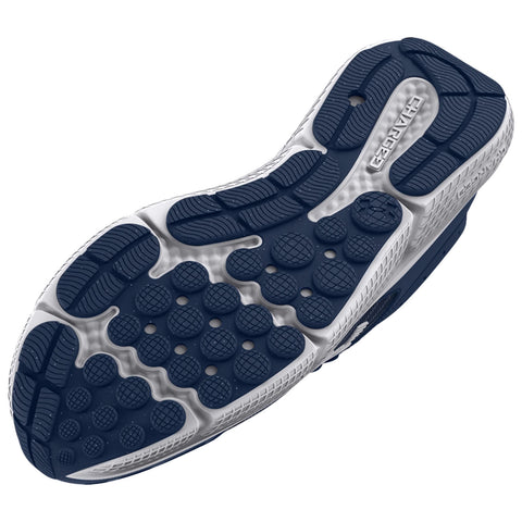 A sneaker's sole with a textured surface featuring circular and grid patterns supports grip and stability on various terrains designed for athletic use and outdoor activities.