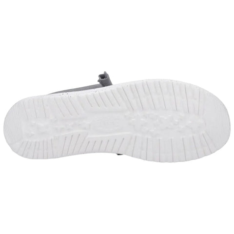 A gray sandal with a textured sole rests on a flat surface showcasing the white outsole pattern suggesting a casual footwear design for warm weather environments.