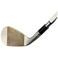 A golf club lies on a flat surface showcasing its worn face with grooves indicating usage its polished metal reflects light while the grip is highlighted against the background.