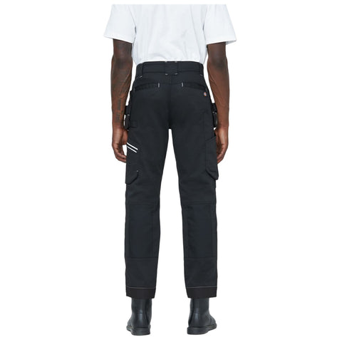 Black cargo pants are worn by a person standing with their back facing the viewer highlighting side pockets and a fitted waist in a plain background.