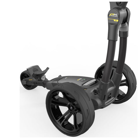 A black golf push cart with large wheels and a sleek design stands on a flat surface. The cart features a console for controlling functionalities and is poised for use on a golf course.