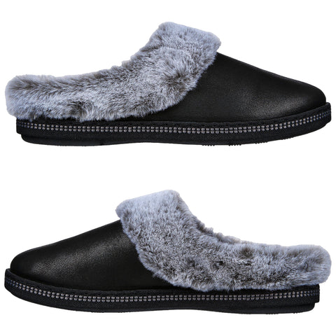 Black slippers with a gray fur lining are displayed side by side showcasing their comfortable design ideal for indoor use on soft surfaces like carpets or hardwood floors.