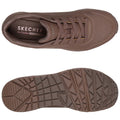 A brown athletic shoe with a textured surface and mesh detailing sits flat showing its laces and perforated sides while the bottom reveals a treaded sole pattern designed for traction. Text reads SKECHERS Air-Cooled MEMORY FOAM.