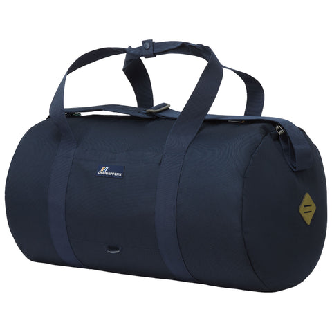 A dark blue duffel bag rests upright featuring two handles and a zippered closure showcasing a logo on the front and a decorative patch on one side