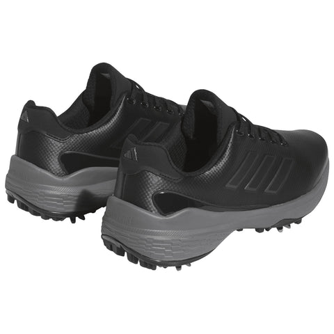 Black athletic shoes with a textured design are positioned side by side showing their laces and multicolored sole designed for grip on grass or turf surfaces