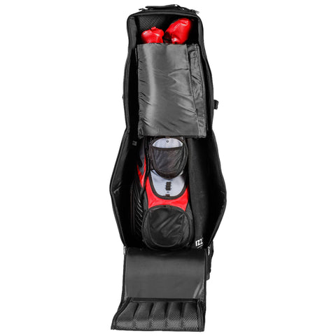 A black golf bag contains red golf clubs and a padded compartment on top in a vertical position placed on a flat surface with additional storage pockets visible on the sides