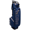 A blue golf bag stands vertically featuring the words ORBITER RAIN DRY on its side with several pockets and a structured top designed for carrying golf clubs and accessories.