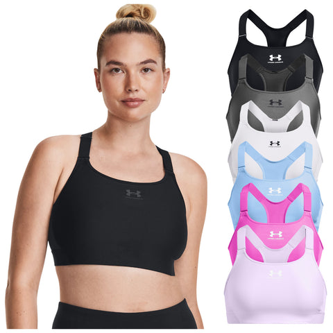 A woman in a black sports bra poses confidently while various colored sports bras hang beside her in a display. The setting is neutral and emphasizes the clothing.