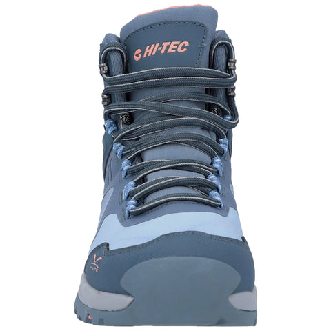 A hiking boot is positioned upright showcasing a combination of dark blue and light blue materials with laces threaded through metal eyelets in a close-up view on a white background.