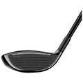 A golf club featuring a sleek black design and a twisted face structure sits against a light background showcasing its smooth surface and aligned grooves intended for striking a golf ball.