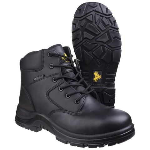 Black waterproof boots are positioned side by side with one boot slightly elevated showing its textured sole designed for grip and stability on various surfaces in an outdoor setting.