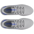 Gray athletic shoes are displayed from a top-down perspective featuring a mesh design and blue accents with laces loosely tied resting on a flat surface.