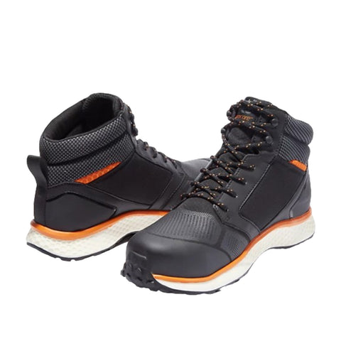 High-top black athletic shoes with textured surfaces and orange accents are positioned with one facing forward and the other slightly turned in a neutral white background setting.