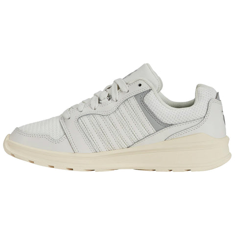 A white athletic sneaker displays a sleek design featuring textured mesh and leather materials as it rests on a flat surface showcasing its lacing system and rubber outsole.