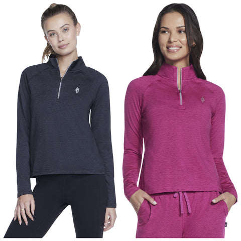 Two women stand side by side wearing athletic quarter-zip shirts in dark gray and fuchsia with long sleeves. They are smiling, showcasing a casual activewear look.