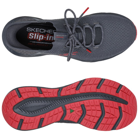 A gray athletic shoe is displayed with a textured upper and red accents The shoe is designed for comfort featuring a slip-on style and a patterned sole suitable for various activities