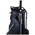 A black golf bag stands upright featuring a logo on the top and an umbrella attached to the side with a zipper pocket visible in the context of sporting equipment.