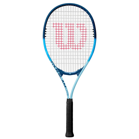 A tennis racket stands upright against a plain background showcasing a blue frame with a white string bed and a prominent red "Wilson" logo in the center of the strings.