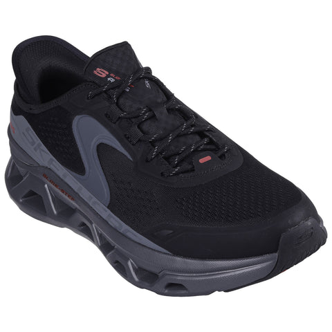 A black athletic shoe with grey accents sits on a flat surface showcasing a mesh upper and thick cushioned sole designed for comfort and performance.