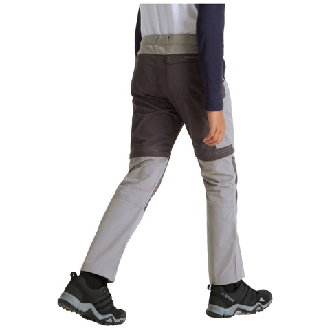 A person is walking wearing dual-colored outdoor pants and black hiking shoes the environment suggests an active outdoor setting likely designed for physical activity or exploration