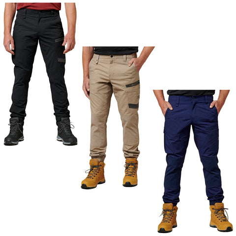 Three pairs of outdoor pants are displayed side by side in black khaki and navy. Each pair features distinct pocket designs. The pants are complemented by rugged hiking boots.